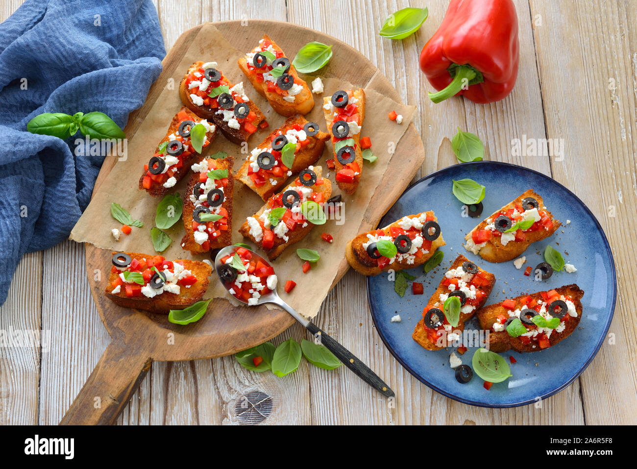 Calda bruschetta greca: croccante cotta piccole fette di pane pita con il formaggio feta, olive nere, peperoncino e basilico, servita come antipasto Foto Stock