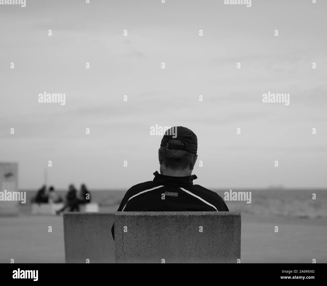 Persona seduta in riva al mare Foto Stock