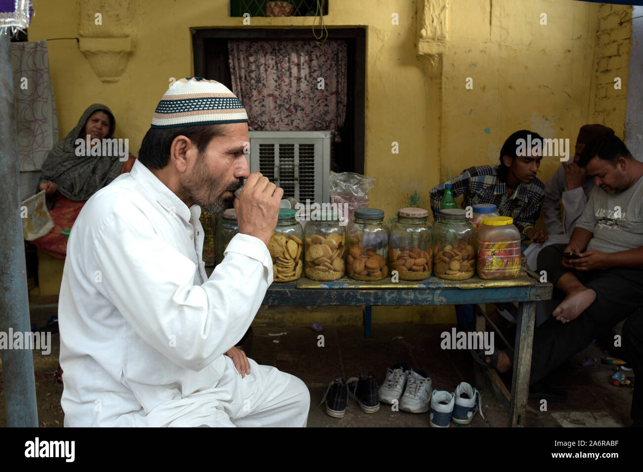 Bevitore di tè presso un negozio di Nizamuddin Dargah, NEW DELHI Foto Stock
