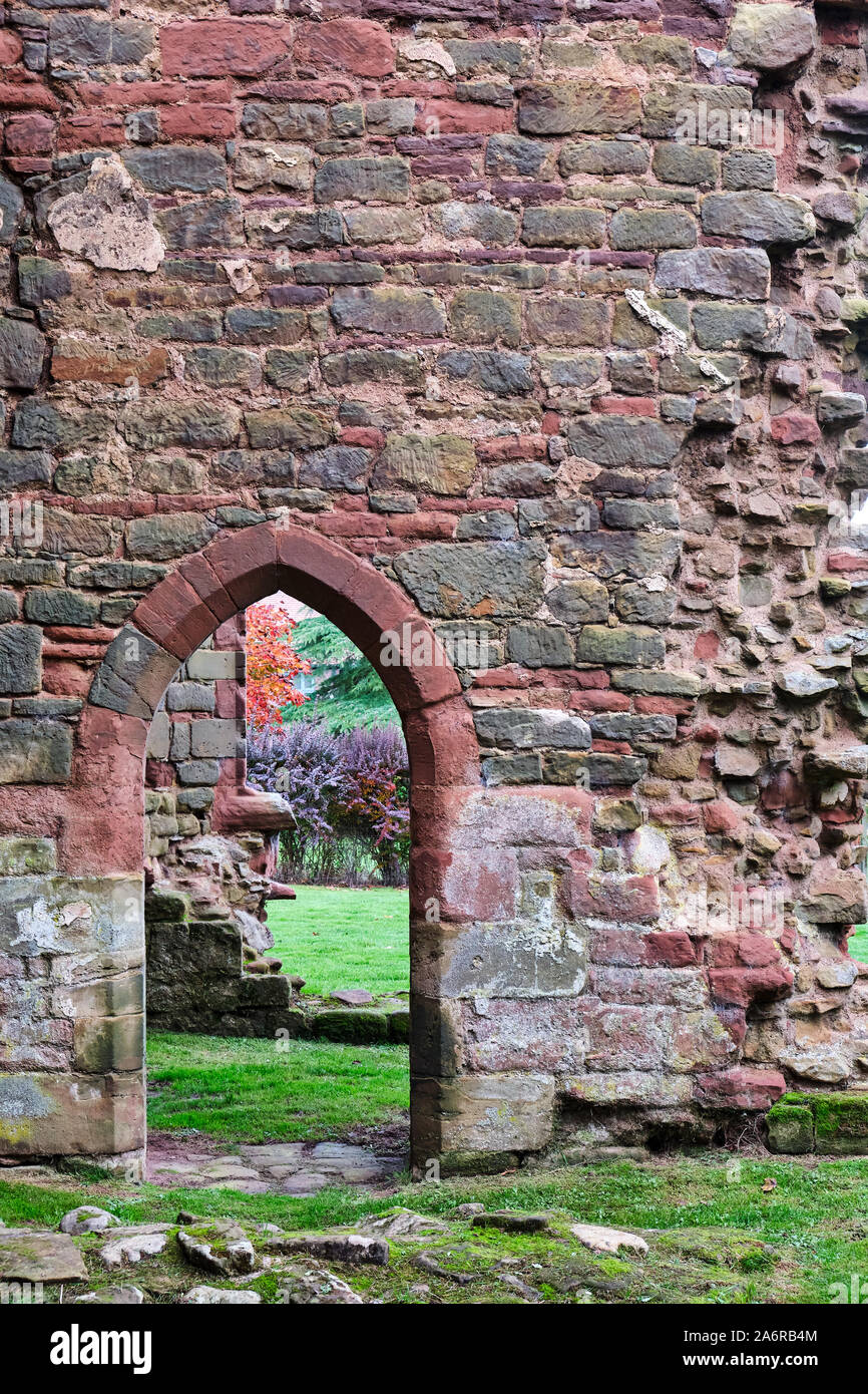 Piccolo portale ad arco in color pastello muro di pietra di rovinato il castello del XIII secolo a Acton Burnell nello Shropshire Foto Stock