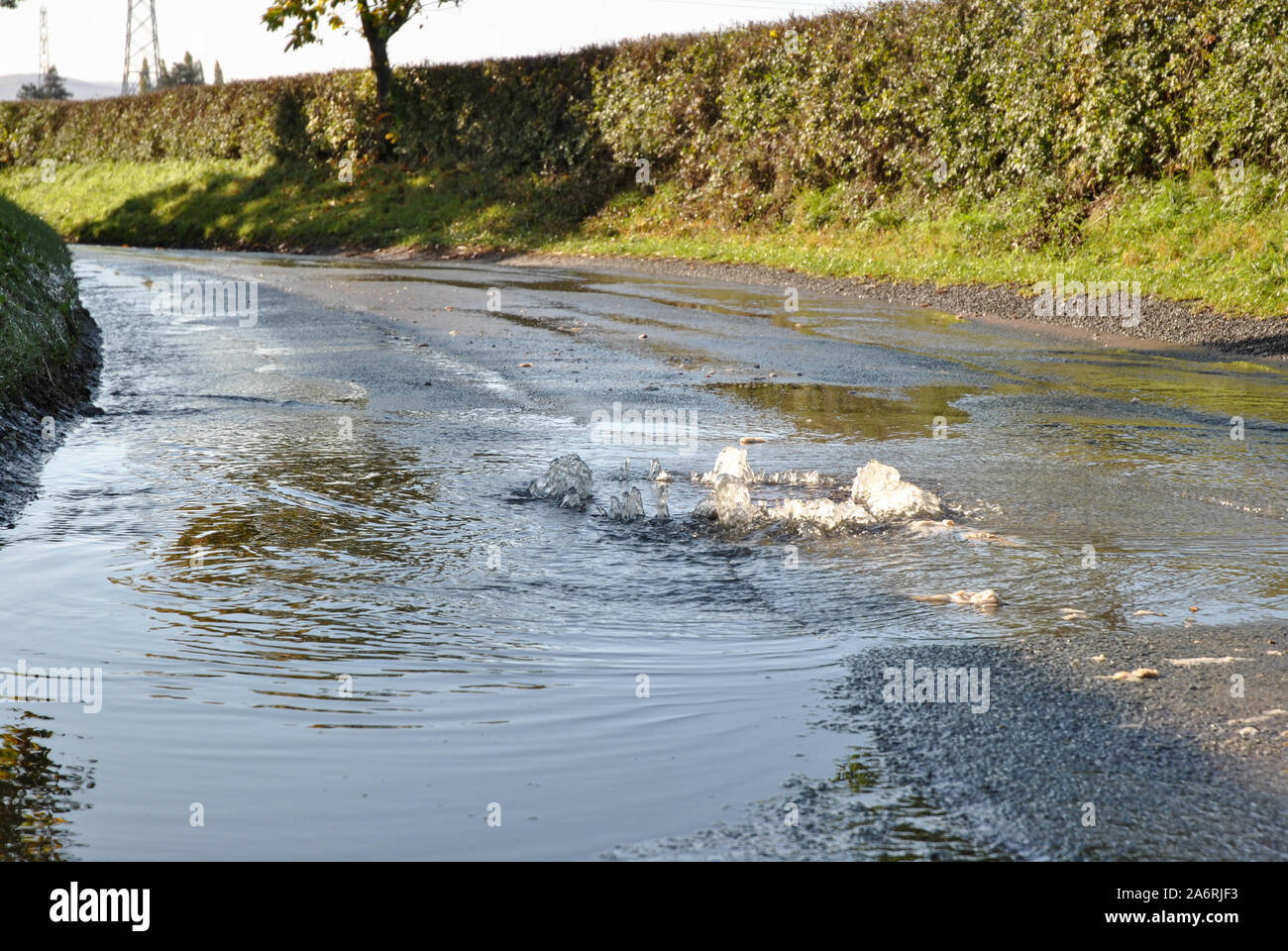 Acqua che sgorga da un pozzo sopraffatto provocati dalle recenti inondazioni in Shropshire, Regno Unito Foto Stock