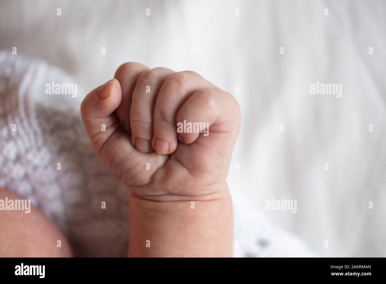 Close up di un bambino serrata a mano in un pugno Foto Stock
