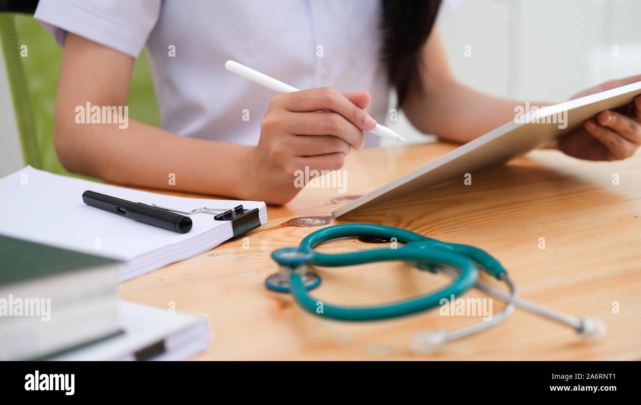 Close up medico esaminando referto medico mentre si utilizza il computer tablet. Settore medicale e della salute concetto. Foto Stock
