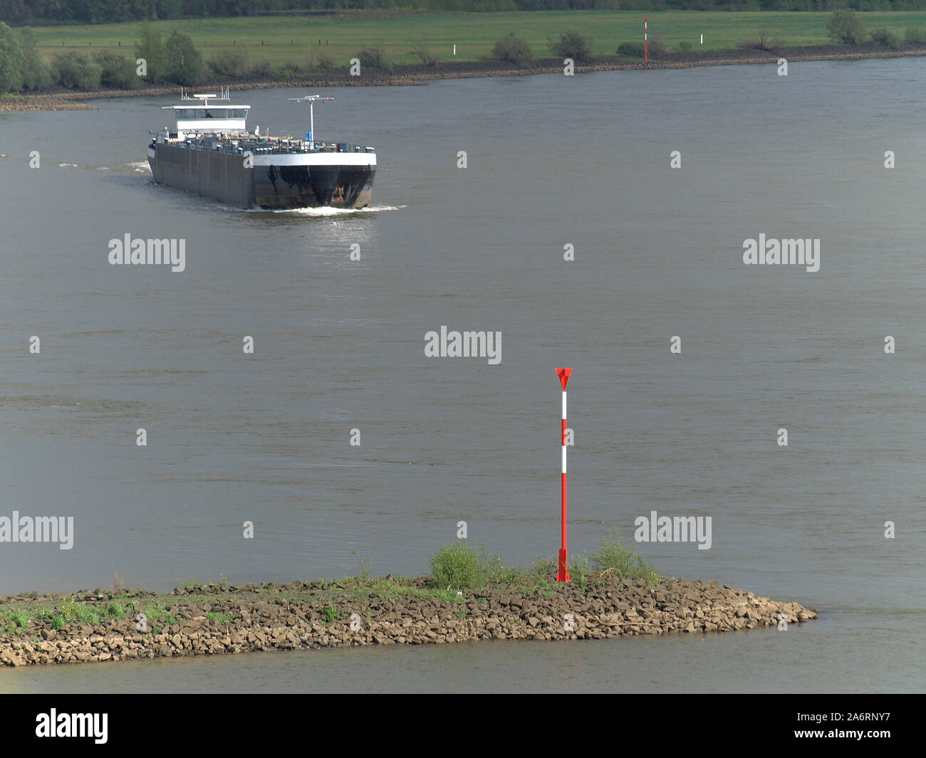 Marchio del mare su un groyne presso il fiume Reno in Rees, merci nave in background Foto Stock