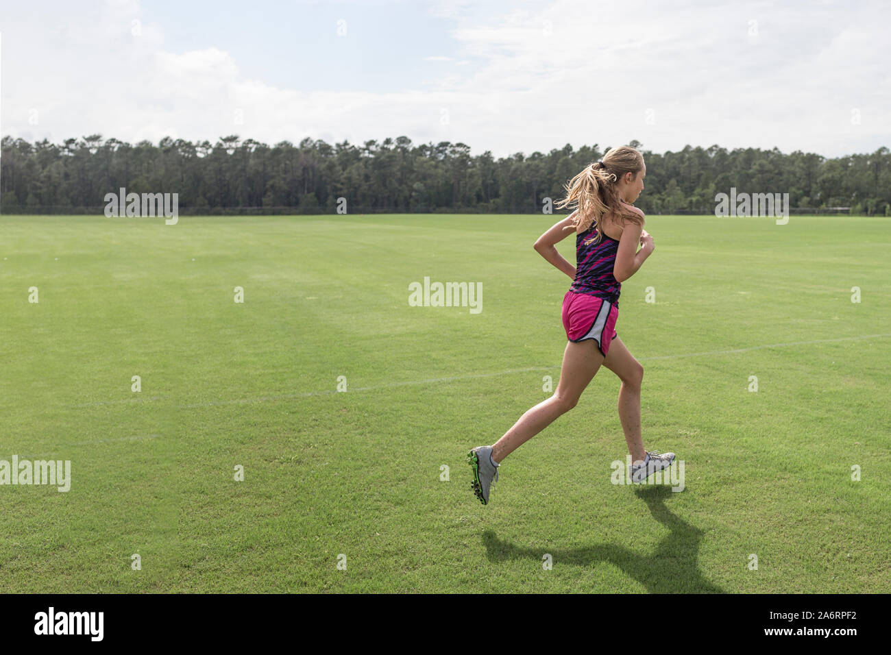 Teen girl cross country runner praticando sprint al campo di calcio Foto Stock