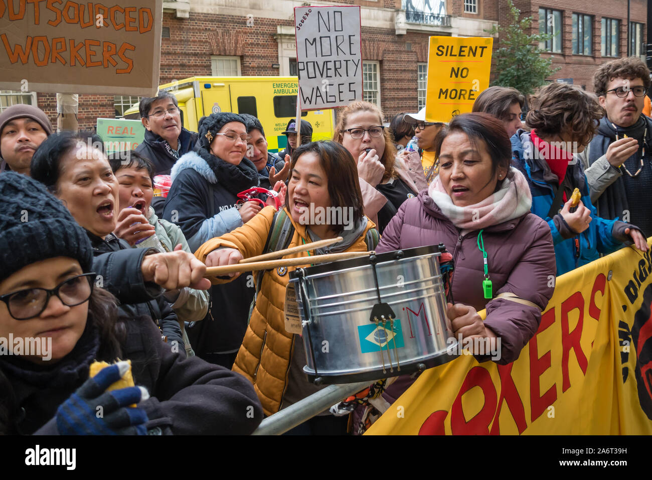 Londra, Regno Unito. Il 28 ottobre 2019. I lavoratori in outsourcing presso l'ospedale St Mary Paddington appartenenti alla Unione UVW protesta fragoroso e danza sulla prima di quindici giorni in programma di scioperi. Circa 200 pulitori, facchini e ristoratori, tutti i migranti e soprattutto le donne occupate dall'altamente redditizio multinazionale SODEXO sono pagato £6-10.000 per ogni anno in meno rispetto ai loro colleghi di NHS di un voto simile, ottenere di gran lunga inferiore minimo legale termini e condizioni e la società ha rifiutato di rispettare i suoi obblighi giuridici per vaccinare il loro. Essi esigono la parità di retribuzione e di condizioni e di trattamento. Peter Marshall / Alamy Live News Foto Stock