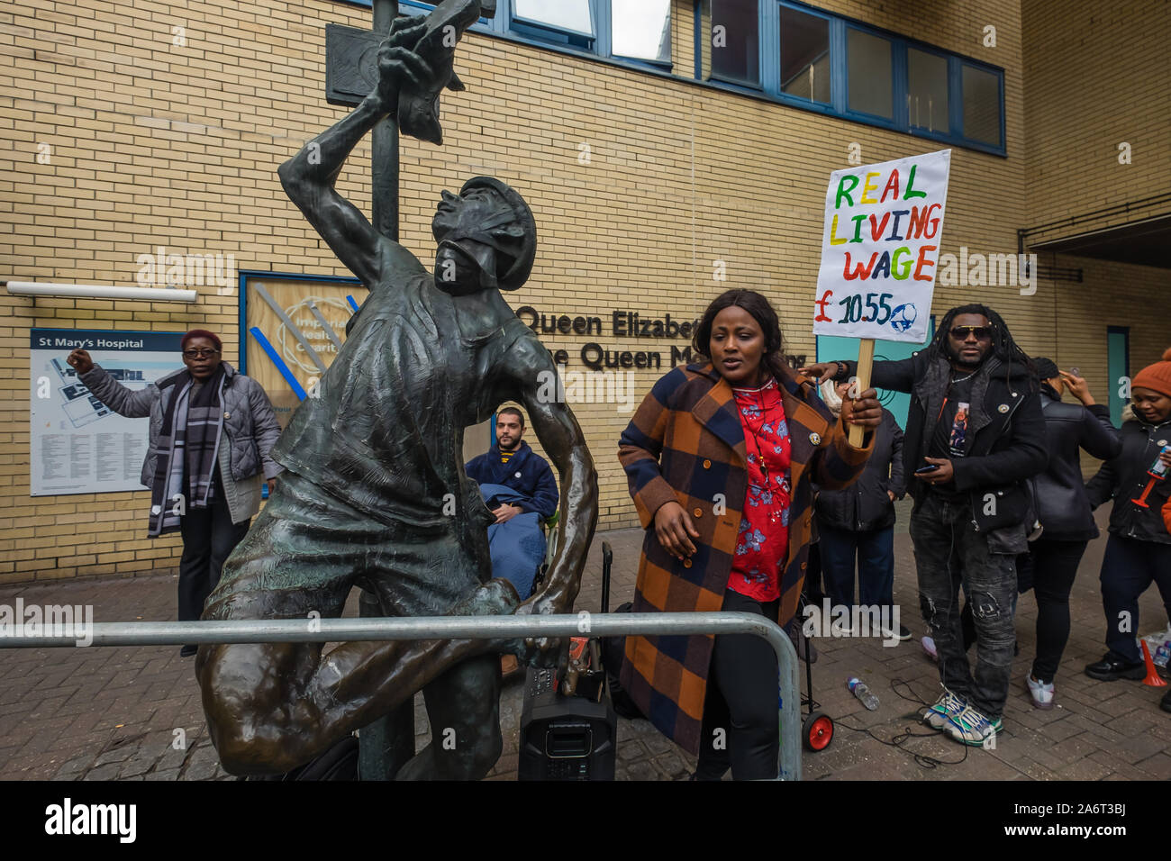 Londra, Regno Unito. Il 28 ottobre 2019. I lavoratori in outsourcing presso l'ospedale St Mary Paddington appartenenti alla Unione UVW protesta fragoroso e danza sulla prima di quindici giorni in programma di scioperi. Circa 200 pulitori, facchini e ristoratori, tutti i migranti e soprattutto le donne occupate dall'altamente redditizio multinazionale SODEXO sono pagato £6-10.000 per ogni anno in meno rispetto ai loro colleghi di NHS di un voto simile, ottenere di gran lunga inferiore minimo legale termini e condizioni e la società ha rifiutato di rispettare i suoi obblighi giuridici per vaccinare il loro. Essi esigono la parità di retribuzione e di condizioni e di trattamento. Peter Marshall / Alamy Live News Foto Stock