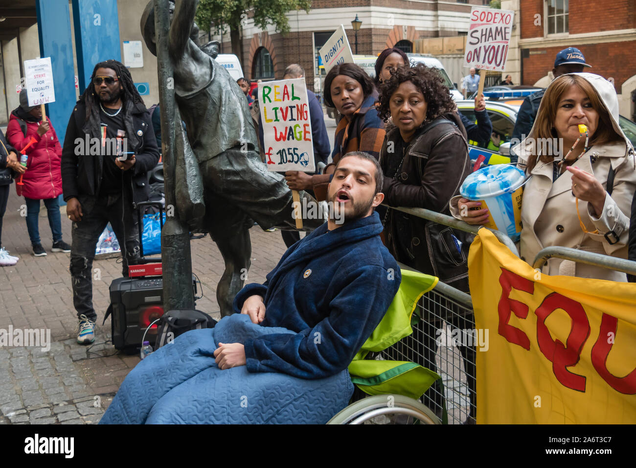 Londra, Regno Unito. Il 28 ottobre 2019. I lavoratori in outsourcing presso l'ospedale St Mary Paddington appartenenti alla Unione UVW protesta fragoroso e danza sulla prima di quindici giorni in programma di scioperi. Circa 200 pulitori, facchini e ristoratori, tutti i migranti e soprattutto le donne occupate dall'altamente redditizio multinazionale SODEXO sono pagato £6-10.000 per ogni anno in meno rispetto ai loro colleghi di NHS di un voto simile, ottenere di gran lunga inferiore minimo legale termini e condizioni e la società ha rifiutato di rispettare i suoi obblighi giuridici per vaccinare il loro. Essi esigono la parità di retribuzione e di condizioni e di trattamento. Peter Marshall / Alamy Live News Foto Stock