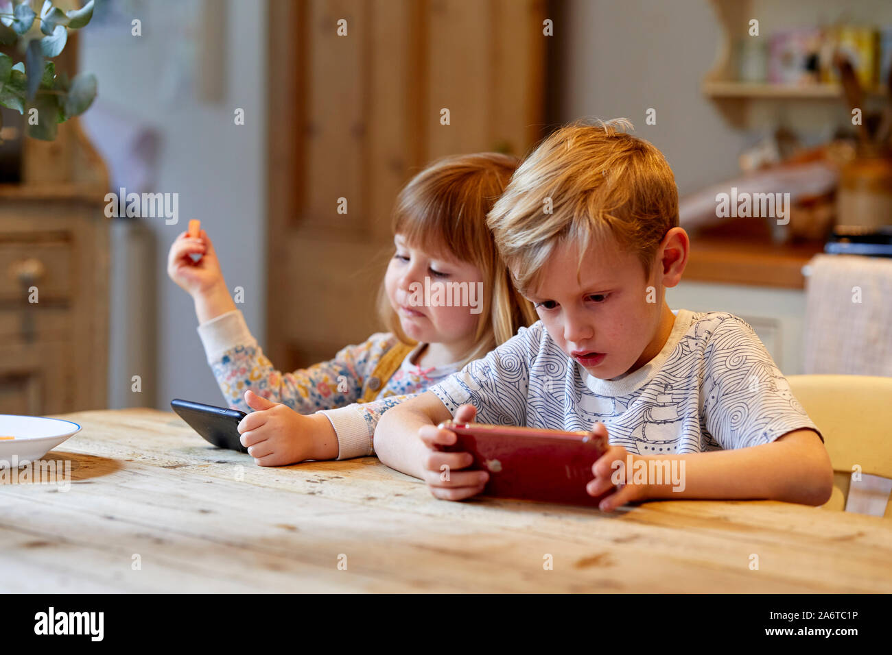 Bambini che giocano sui dispositivi Foto Stock