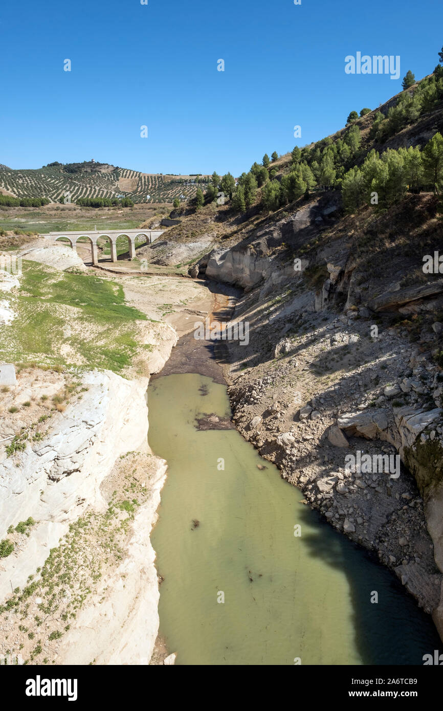 A causa delle scarse precipitazioni nella tarda estate, bassi livelli di acqua di esporre un vecchio ponte romano normalmente sott'acqua. Serbatoio Iznajar, Andalusia. Spagna Foto Stock