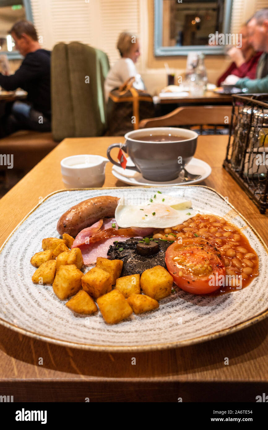 Una completa colazione inglese colazione cucinata in un ristorante con salsicce, pancetta, uova, fagioli al forno, pomodori, funghi e patate fritte in un ristorante. Foto Stock