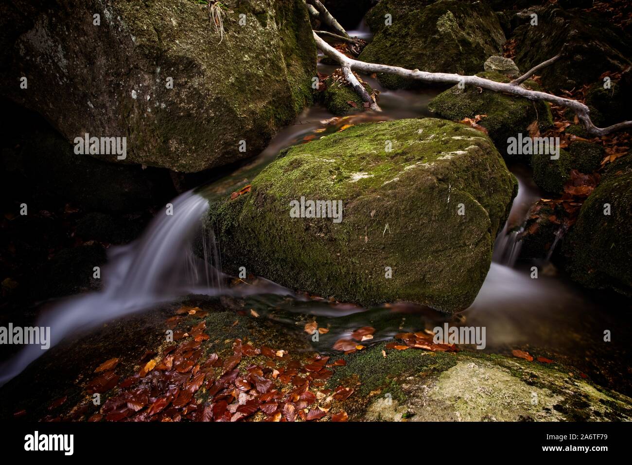 Autunno lunga esposizione del Creek e nero (grande) Stolpich cascate in Jizera Mountain. L'acqua cade in un profondo canyon di foresta piena di pietre di granito Foto Stock
