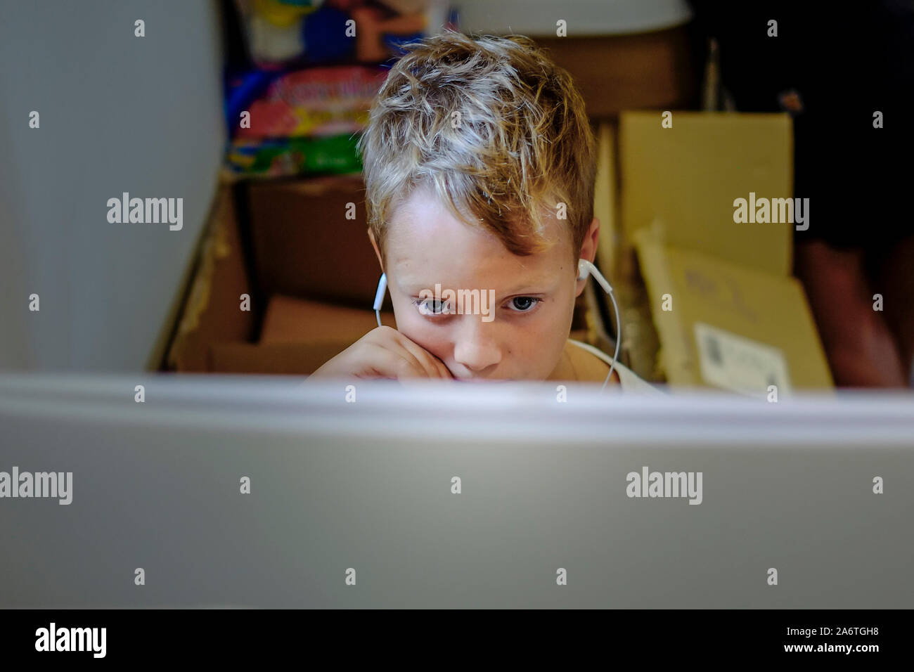 Un giovane ragazzo assorto in riproduzione di un computer video gioco su un computer. Foto Stock