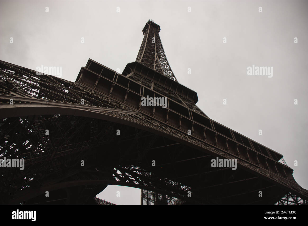 Extreme a basso angolo di Torre Eiffel in una giornata nuvolosa a Parigi, Francia - Orizzontale shot del principale punto di riferimento della città di amore - il turismo europeo - GRE Foto Stock
