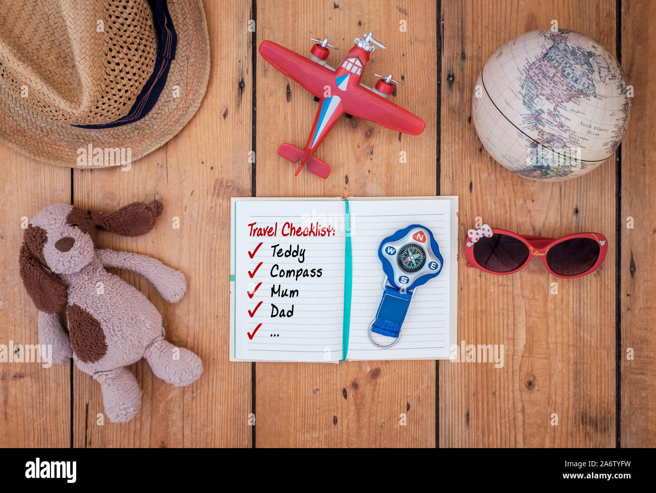 Bambino il diario di viaggio e gli accessori stabiliti sul vecchio tavolo in legno. Una lista di controllo di marcia è leggibile. Concetto di viaggio Foto Stock