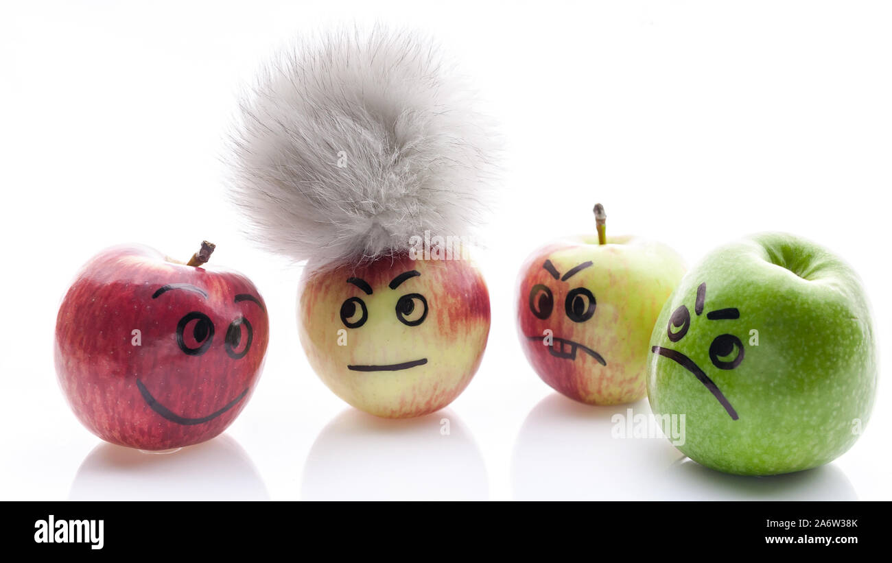 Volto dipinto mele. Jolly e triste mele divertenti. Verde e mele rosse su uno sfondo bianco. Foto Stock