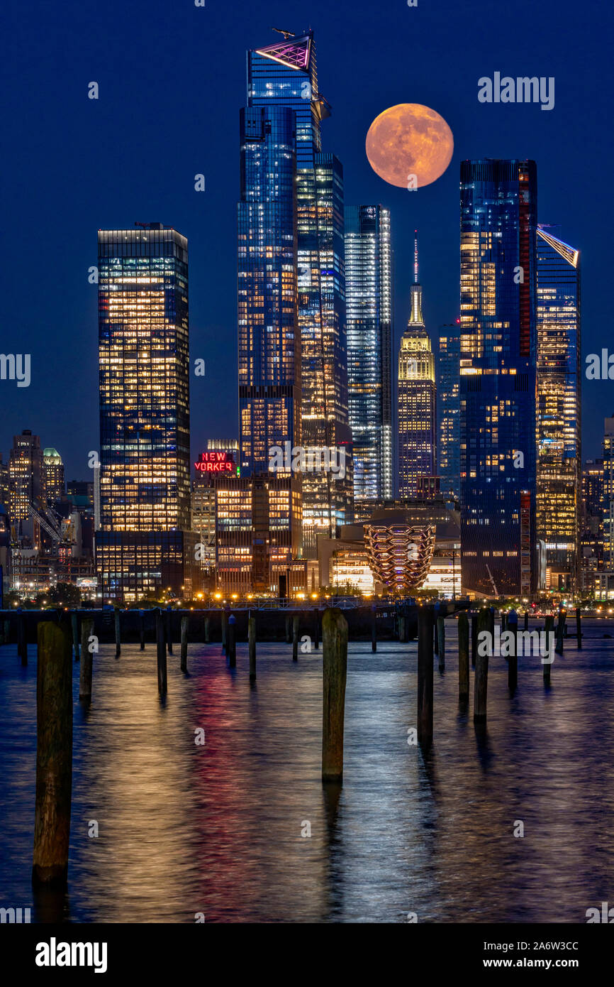Cantieri di Hudson NYC e Luna Piena - l' Empire State Building è circondato dai nuovi grattacieli di Hudson cantiere che compongono le sempre mutevoli di New York Foto Stock