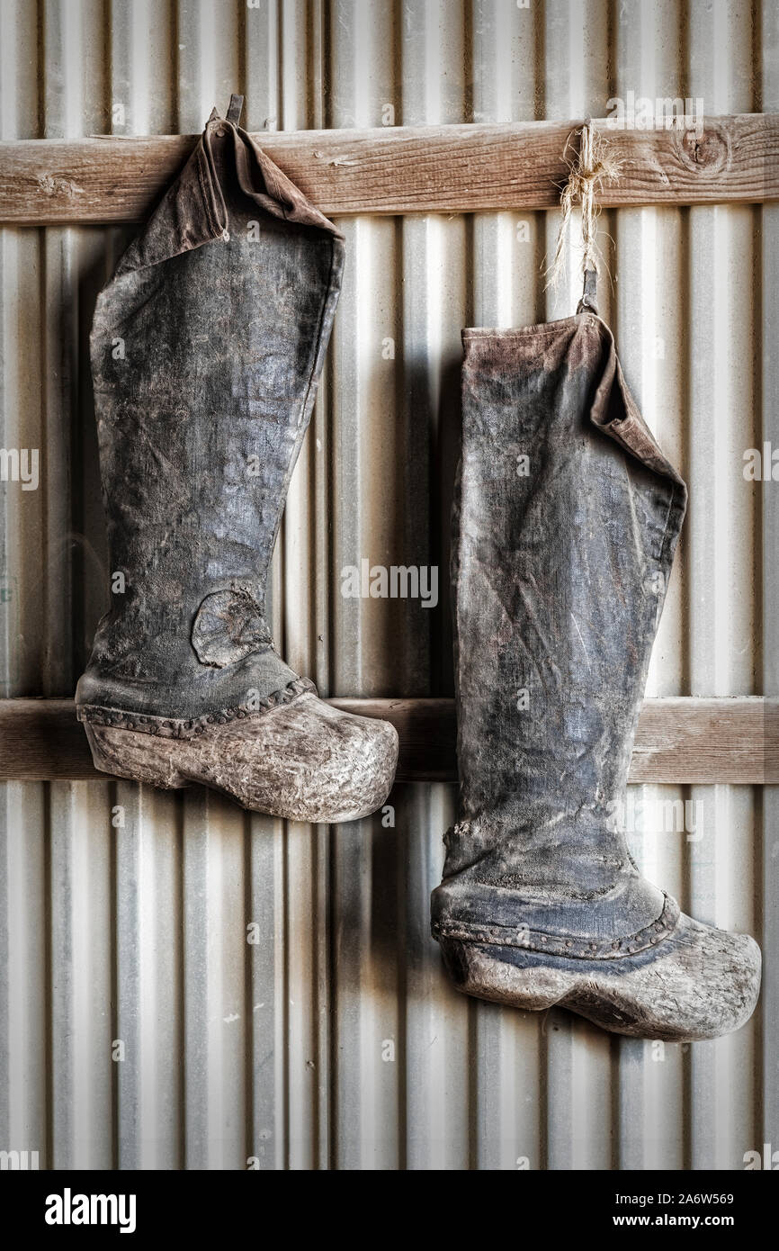 Stivali di allevamento - indossato stivali di allevamento appeso per la giornata all'interno di un fienile. Foto Stock