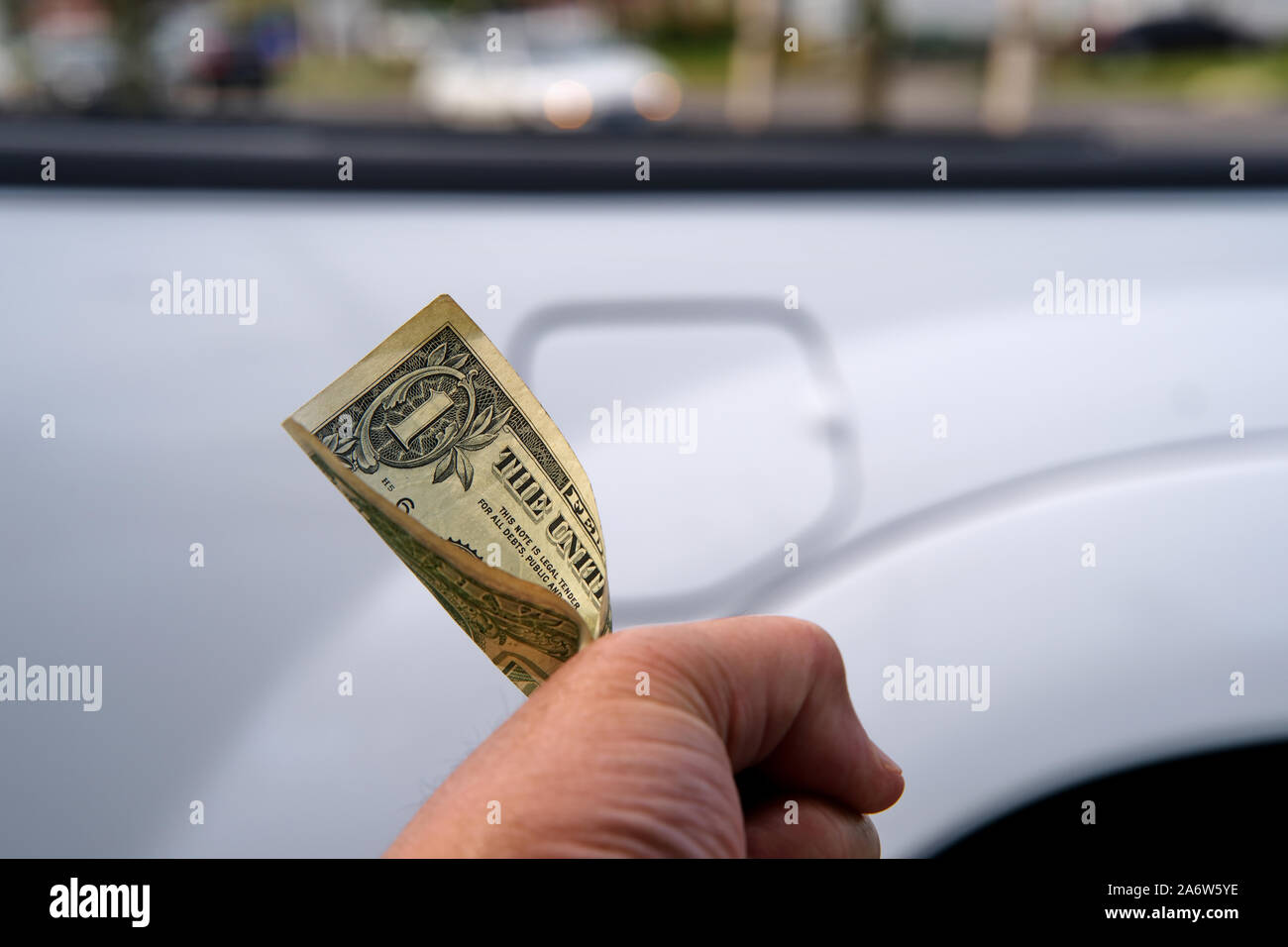 I clienti lato dolorosamente partecipazione a un dollaro accanto al suo pick up trucks sportello del bocchettone di rifornimento serbatoio carburante. Foto Stock