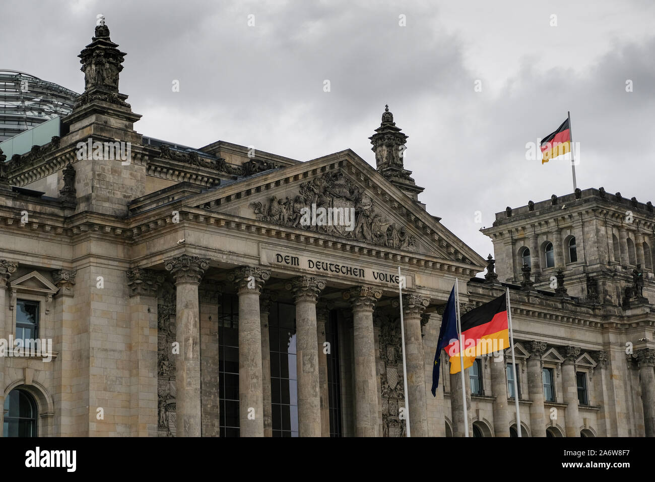 Berlino famosa storica facciata del Reichstag tedesco con bandiere su cielo nuvoloso,il simbolo Foto Stock