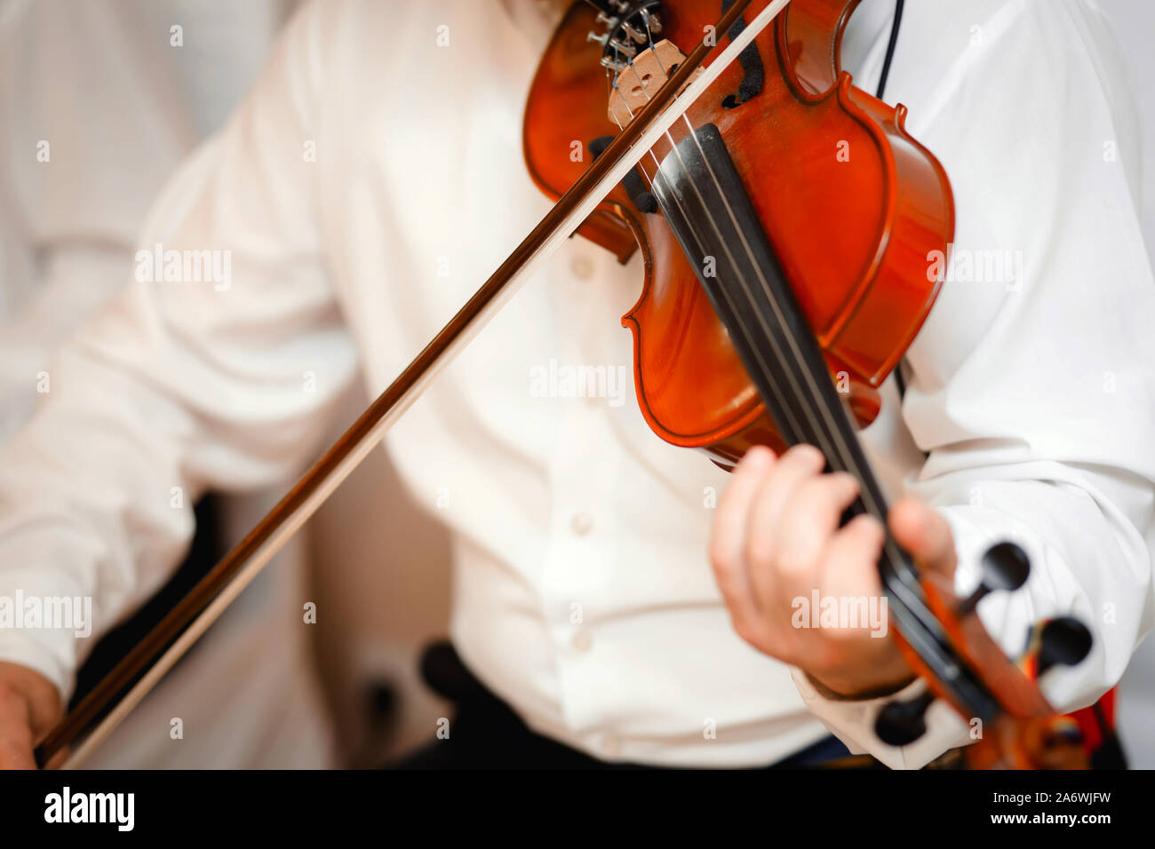 Il violino viola musicista che gioca . L'uomo violinista classico strumento musicale violino . Close up giovane violinista vestito elegantemente giocando su woo Foto Stock