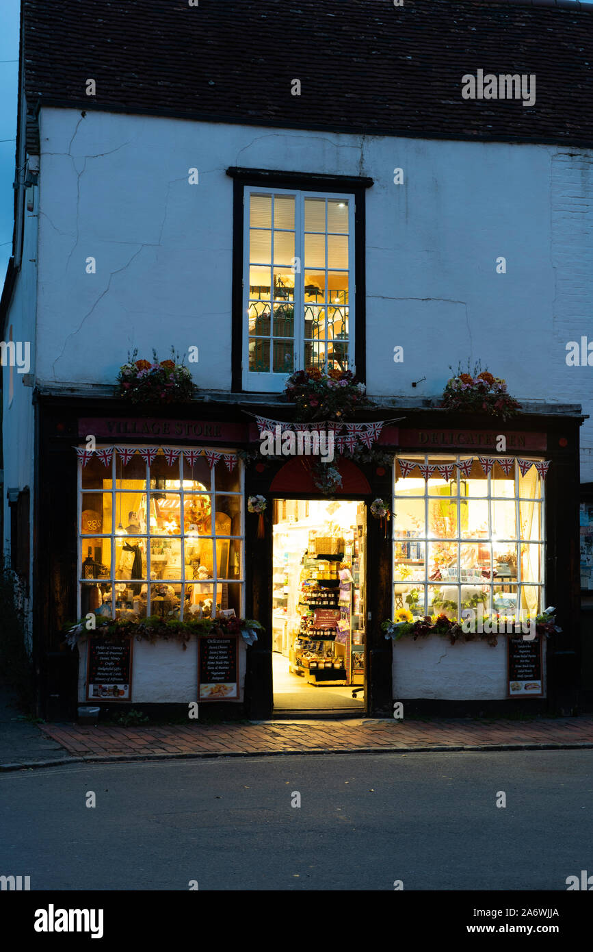 Alfriston village store, ufficio postale e delicatessen illuminata su una sera d'autunno, East Sussex, Regno Unito Foto Stock