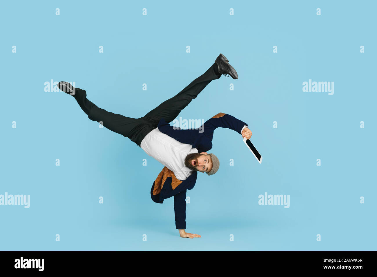 Giovane imprenditore caucasico divertirsi ballare break dance su blu di sfondo per studio. Gestione, flessibile, libertà, attività professionale, un modo alternativo di lavoro moderno. Ama il suo lavoro. Copyspace. Foto Stock