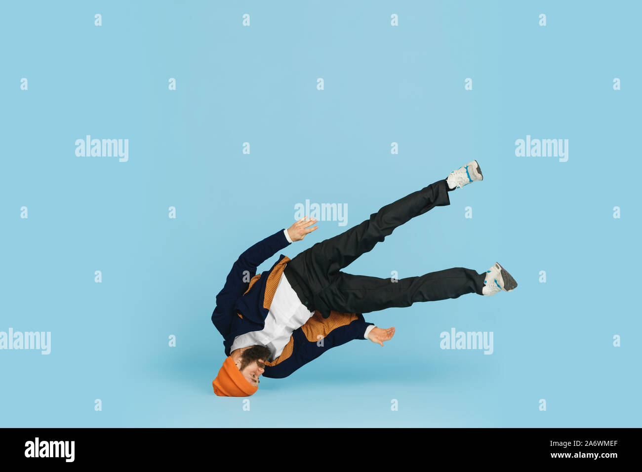 Giovane imprenditore caucasico divertirsi ballare break dance su blu di sfondo per studio. Gestione, flessibile, libertà, attività professionale, un modo alternativo di lavoro moderno. Ama il suo lavoro. Copyspace. Foto Stock