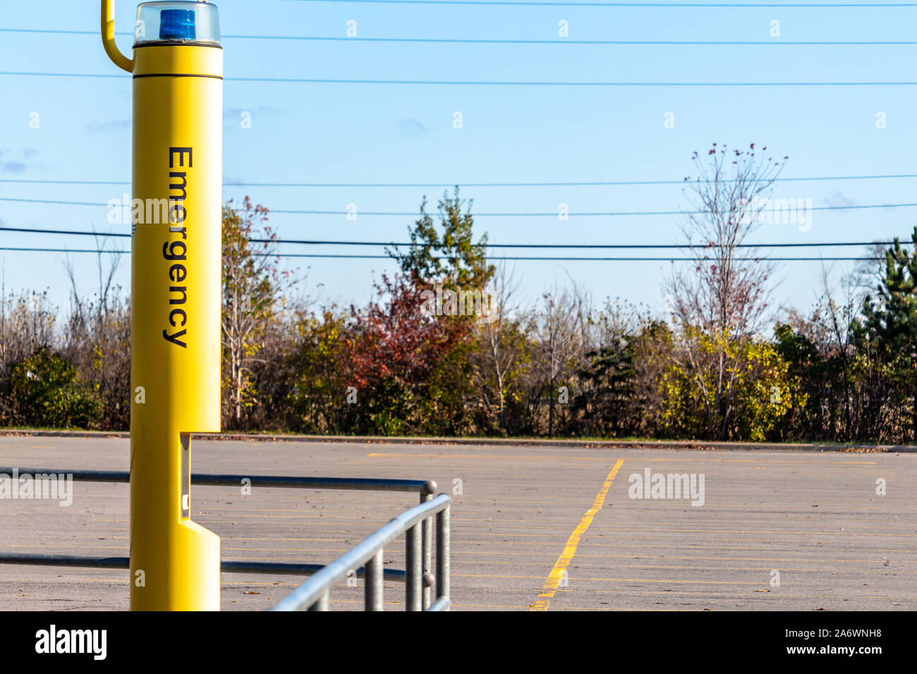 Un polo gialla in piedi in un parcheggio pubblico dispone di una luce blu e un citofono per richiedere aiuto. La parola "emergenza" viene visualizzata sul lato di Foto Stock