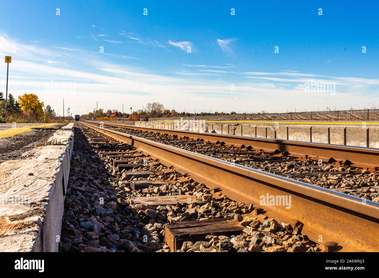 Su un perlopiù limpida giornata, fine auto passeggeri del treno può essere visto nel lontano orizzonte si allontana. I binari ferroviari vengono visualizzati a basso avanti e indietro Foto Stock