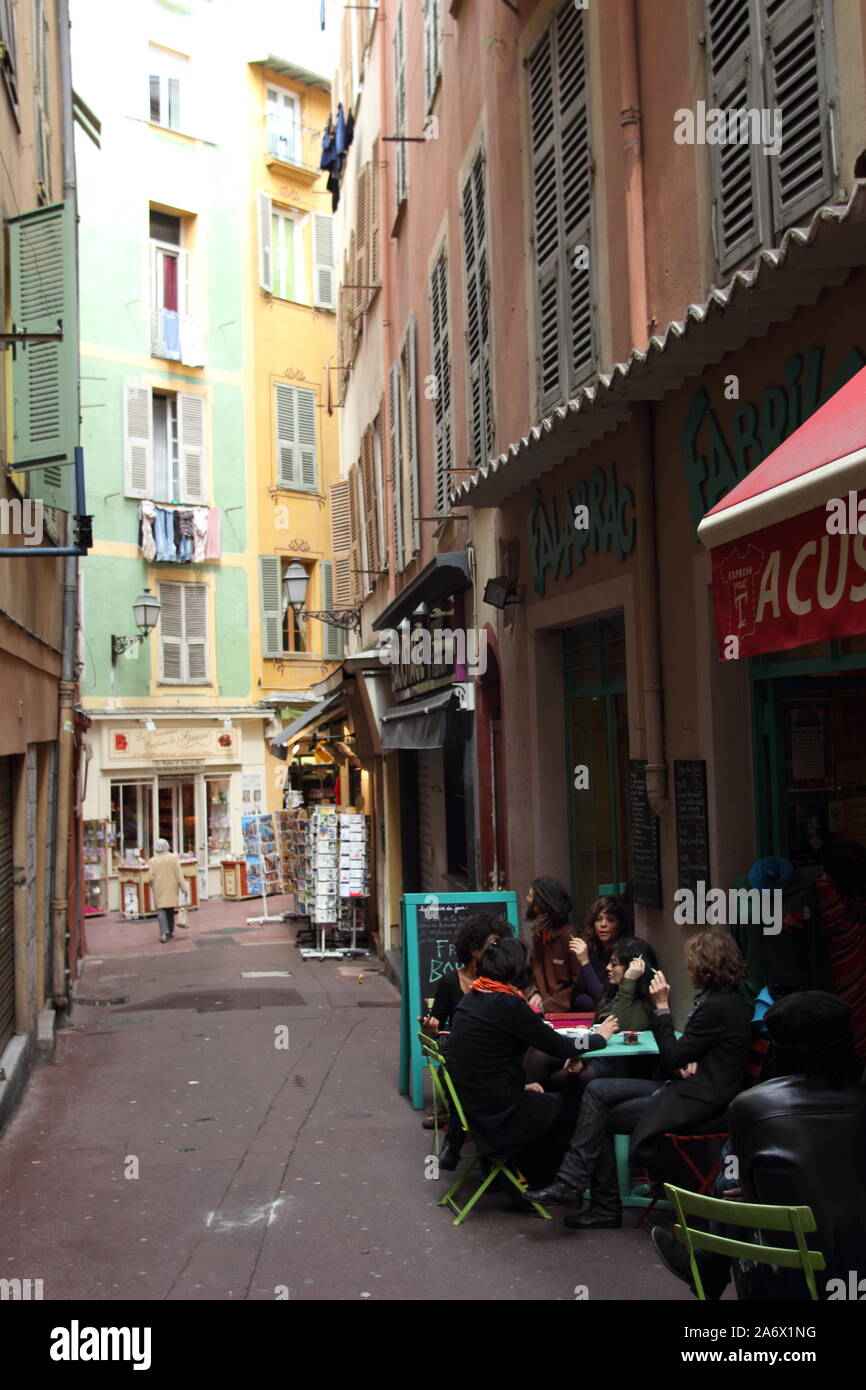 Arty giovani a un tavolo del bar in un vicolo del centro storico, Nice, Francia Foto Stock