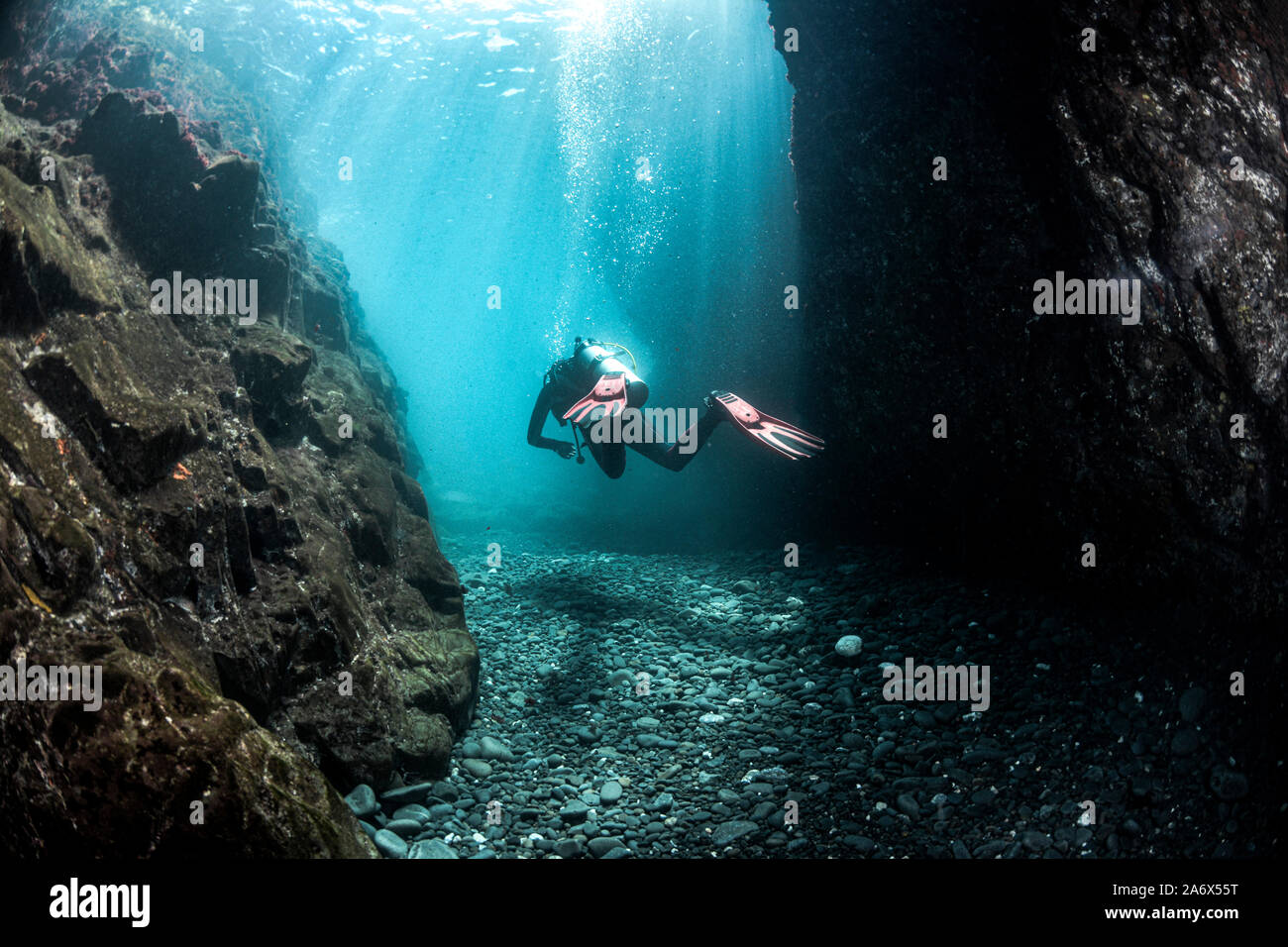 Scuba Diver tra le pareti con un bellissimo sole e ombre Foto Stock