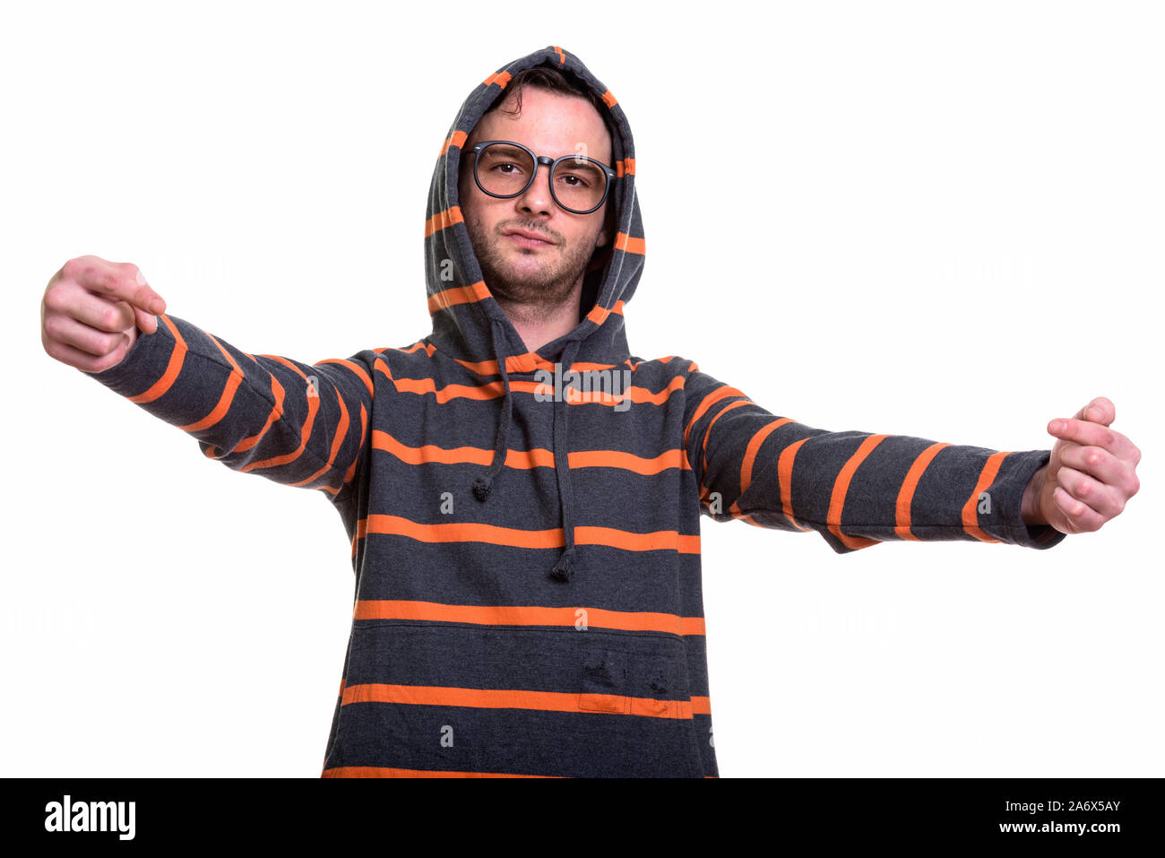 Studio shot del giovane uomo felpa con cappuccio da indossare durante il puntamento fing entrambi Foto Stock