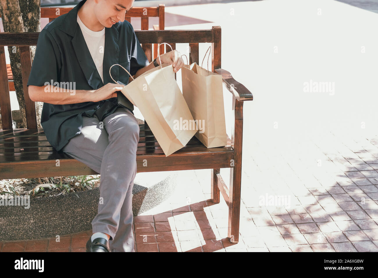 Uomo che guarda all'interno di shopping bag. Il consumismo lifestyle Foto Stock