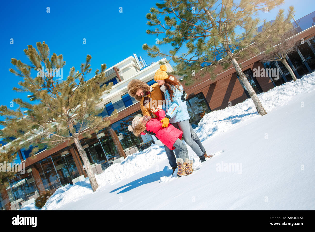 Vacanza invernale. Tempo per la famiglia insieme all'aperto uomo azienda ragazza ridere di filatura eccitato Foto Stock