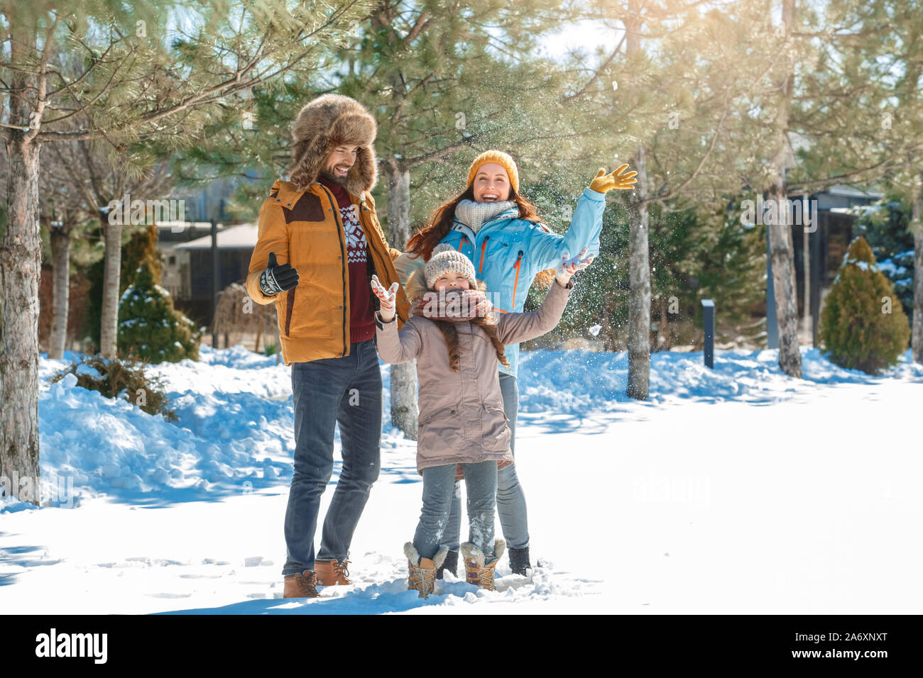 Vacanza invernale. Tempo per la famiglia insieme all'aperto gettando la neve fino a ridere eccitato Foto Stock