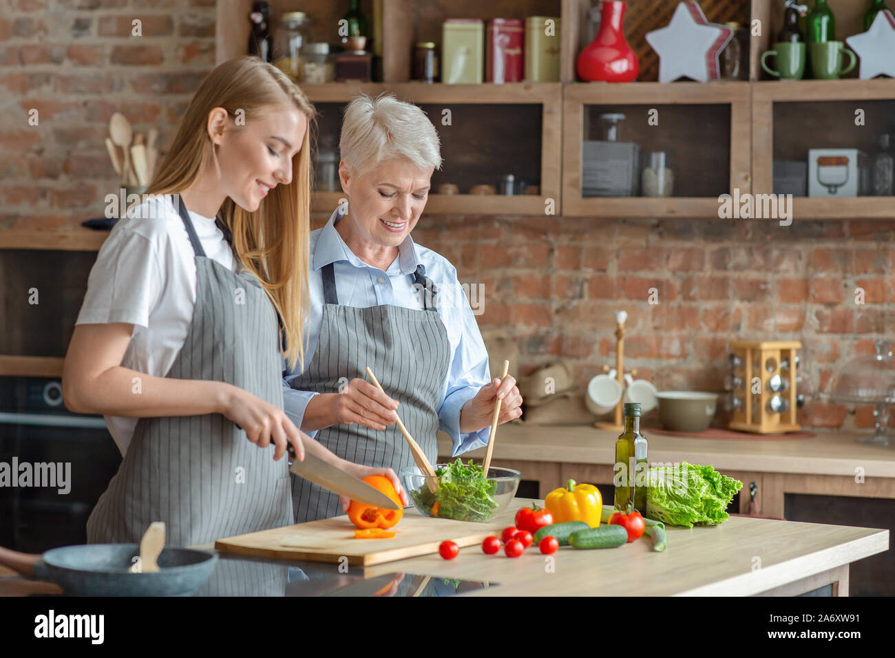 Giovane donna Cottura sana insalata di verdure con età compresa tra mom Foto Stock