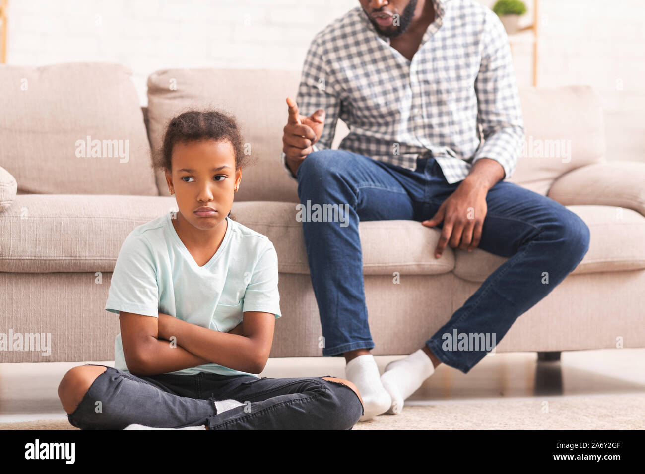 Arrabbiato nero padre scolding testardo piccola figlia per il cattivo comportamento Foto Stock