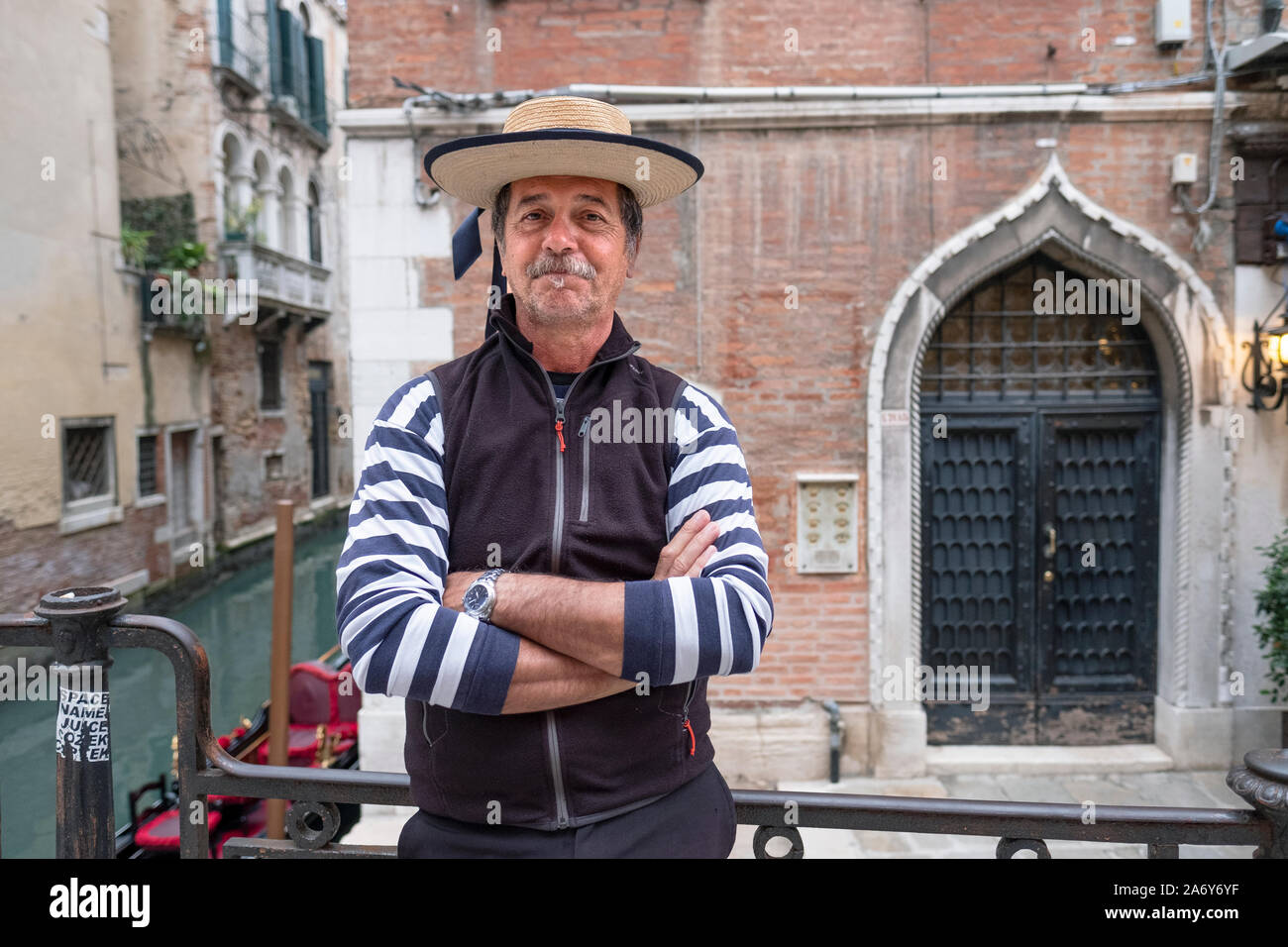 Poste ritratto di un gondoliere su una strada posteriore a Venezia, Italia. Foto Stock