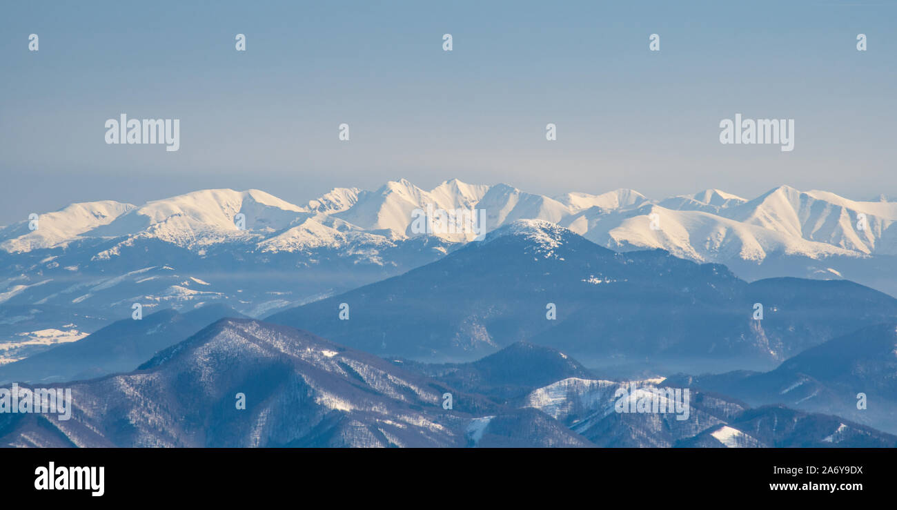 Spettacolare Zapadne Tatry mountain range scenario da Velka luka hill sul foro di Martinske in Lucanska Mala Fatra montagne in Slovacchia durante il giorno di inverno Foto Stock