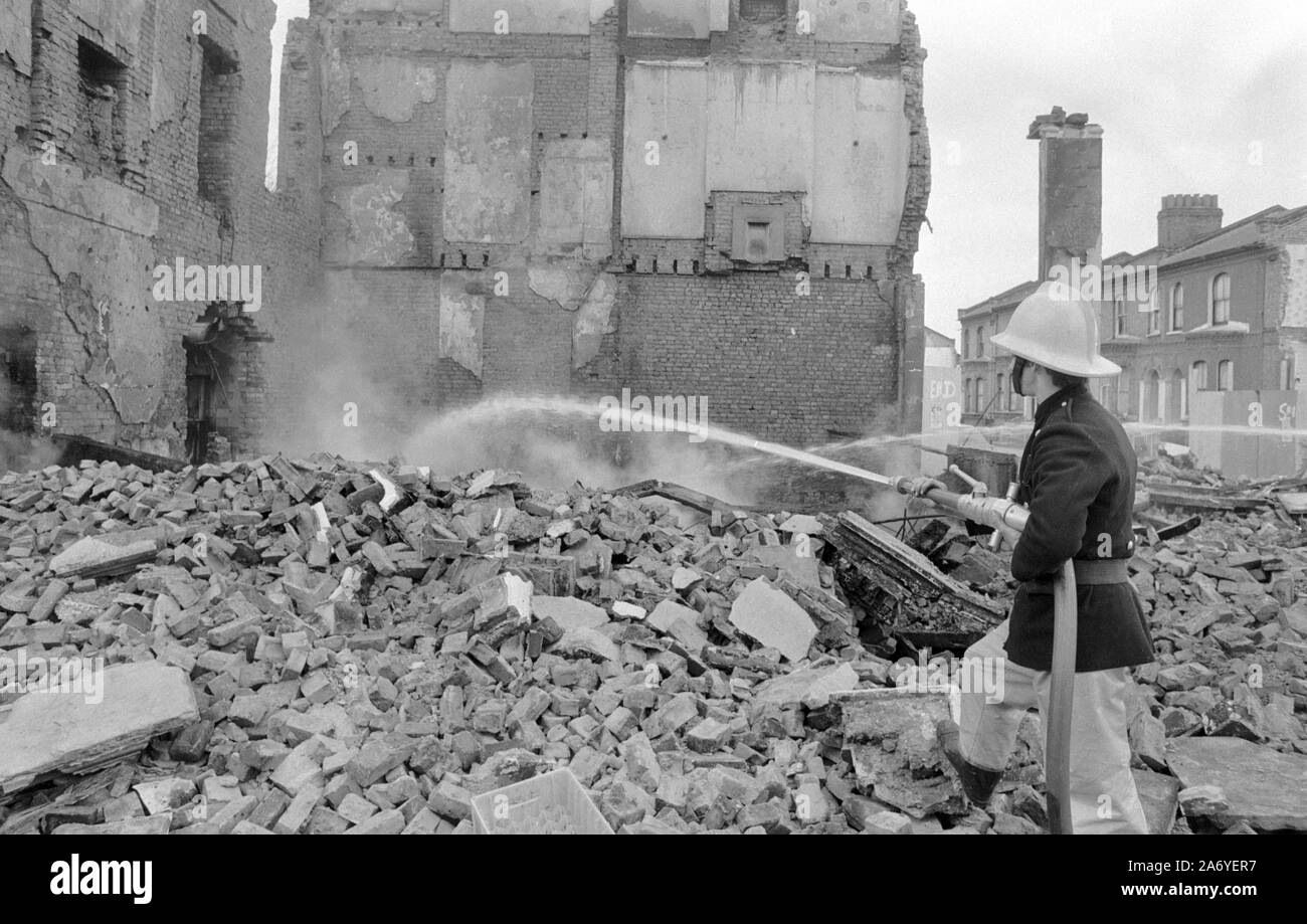 I vigili del fuoco di smorzare le macerie di quello che fu il Castello di Windsor public house in Mayall Road, Brixton, Londra. L'angolo pub è stata accidentalmente colpito da una Molotov cocktail finalizzate alla polizia. Foto Stock