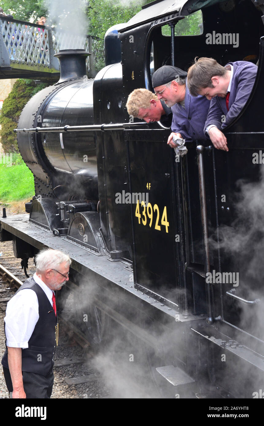 Treno a vapore e driver per i vigili del fuoco di parlare di guardia, KWVR, Keighley e Worth Valley Railway, Foto Stock