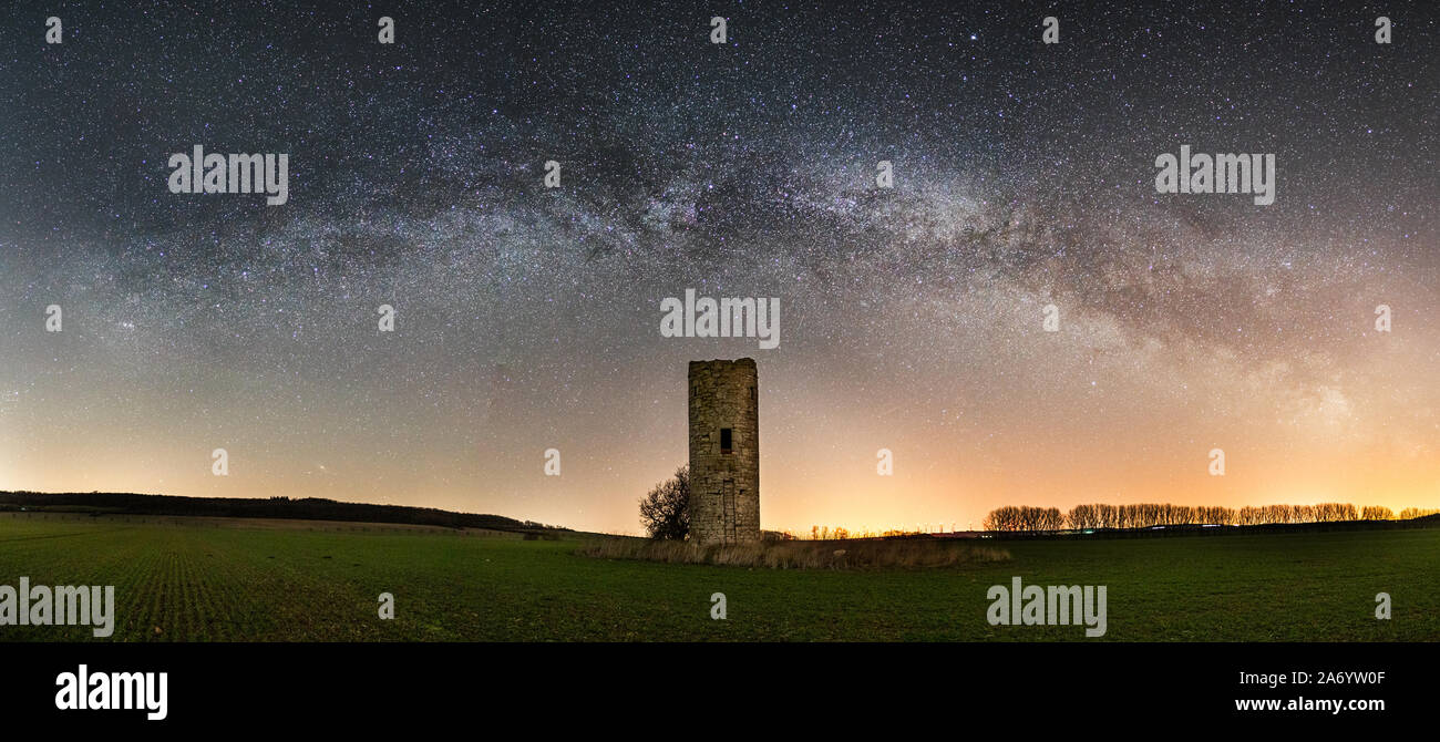 Panorama Via Lattea con una vecchia torre storica Foto Stock