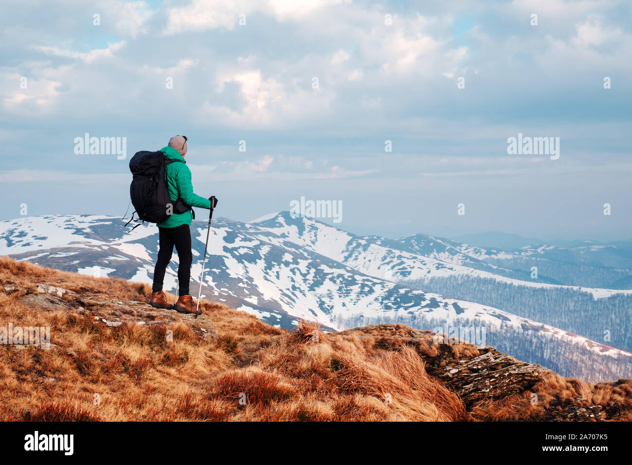 Un paesaggio fantastico con le montagne nevose gamma e il viaggiatore con zaino su un primo piano Foto Stock