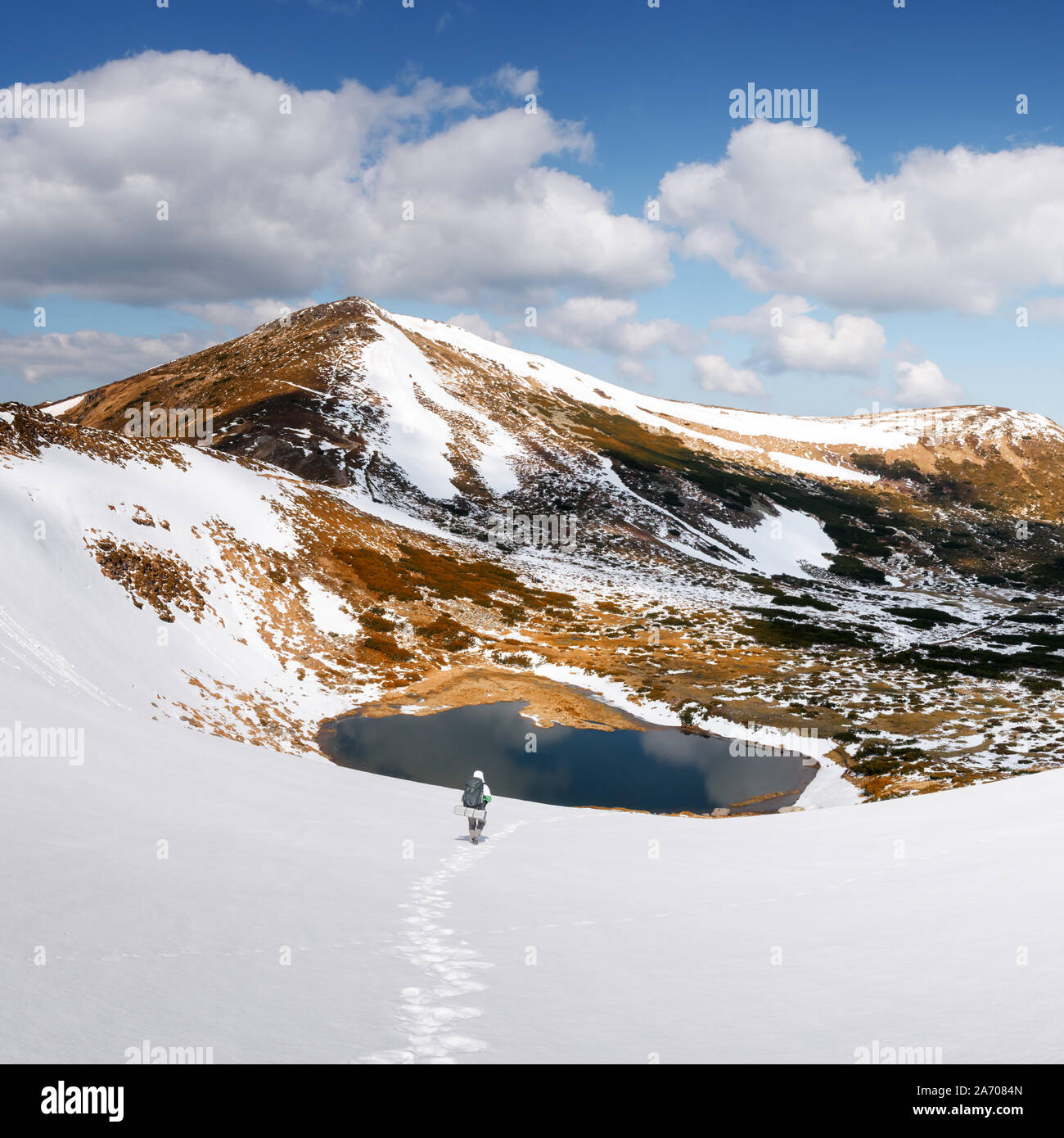 Un paesaggio fantastico con il lago in primavera montagne innevate Foto Stock