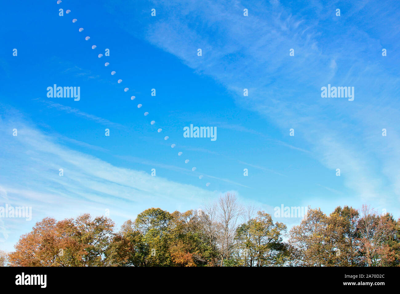 Foto composito Luna tracking attraverso il cielo blu verso il basso e verso la Autunno Autunno boschi, Foto Stock