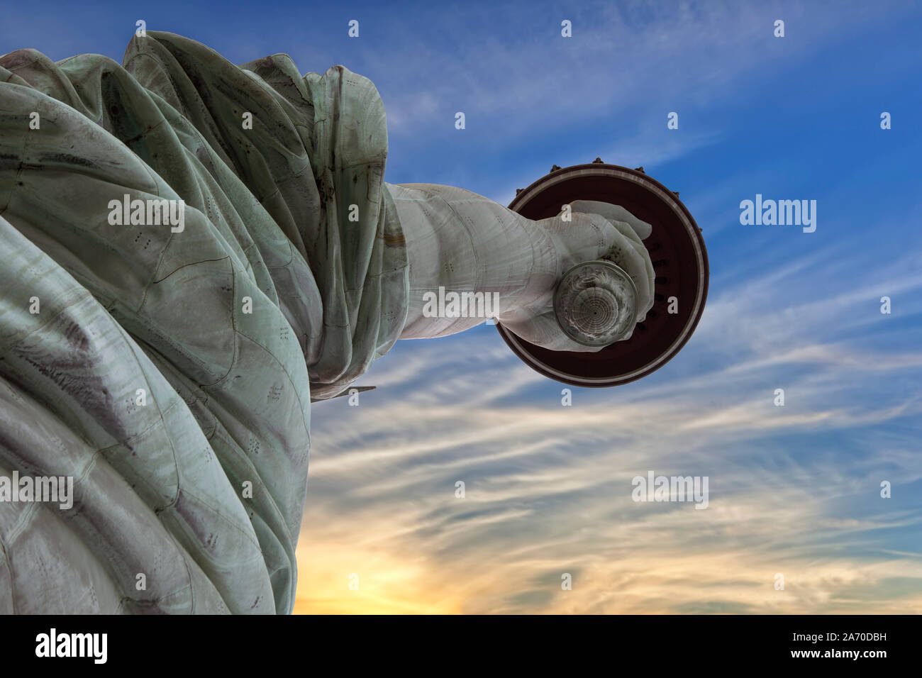 Extreme close up di mano e la fiaccola della statua della libertà di sunrise, guardando dal suolo. Foto Stock