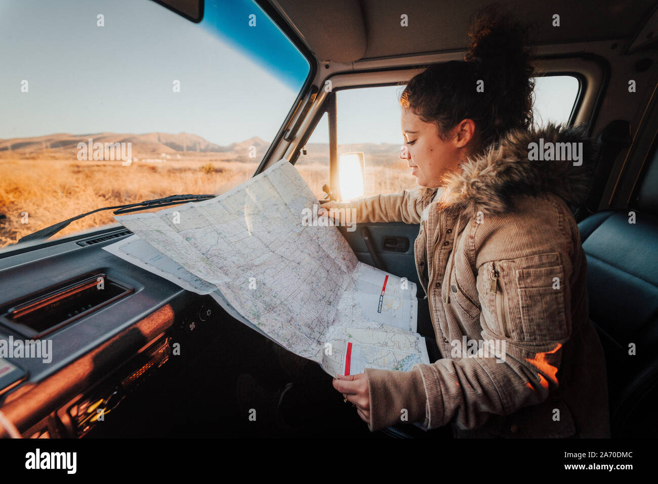 Giovane donna guardando una mappa durante un Californian road trip Foto Stock