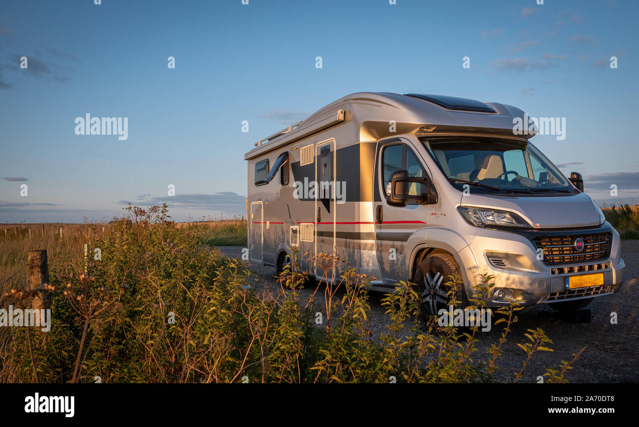 Camper camper RV con biciclette parcheggio in un bellissimo luogo paradisiaco su una collina con il tramonto e vista mozzafiato Foto Stock