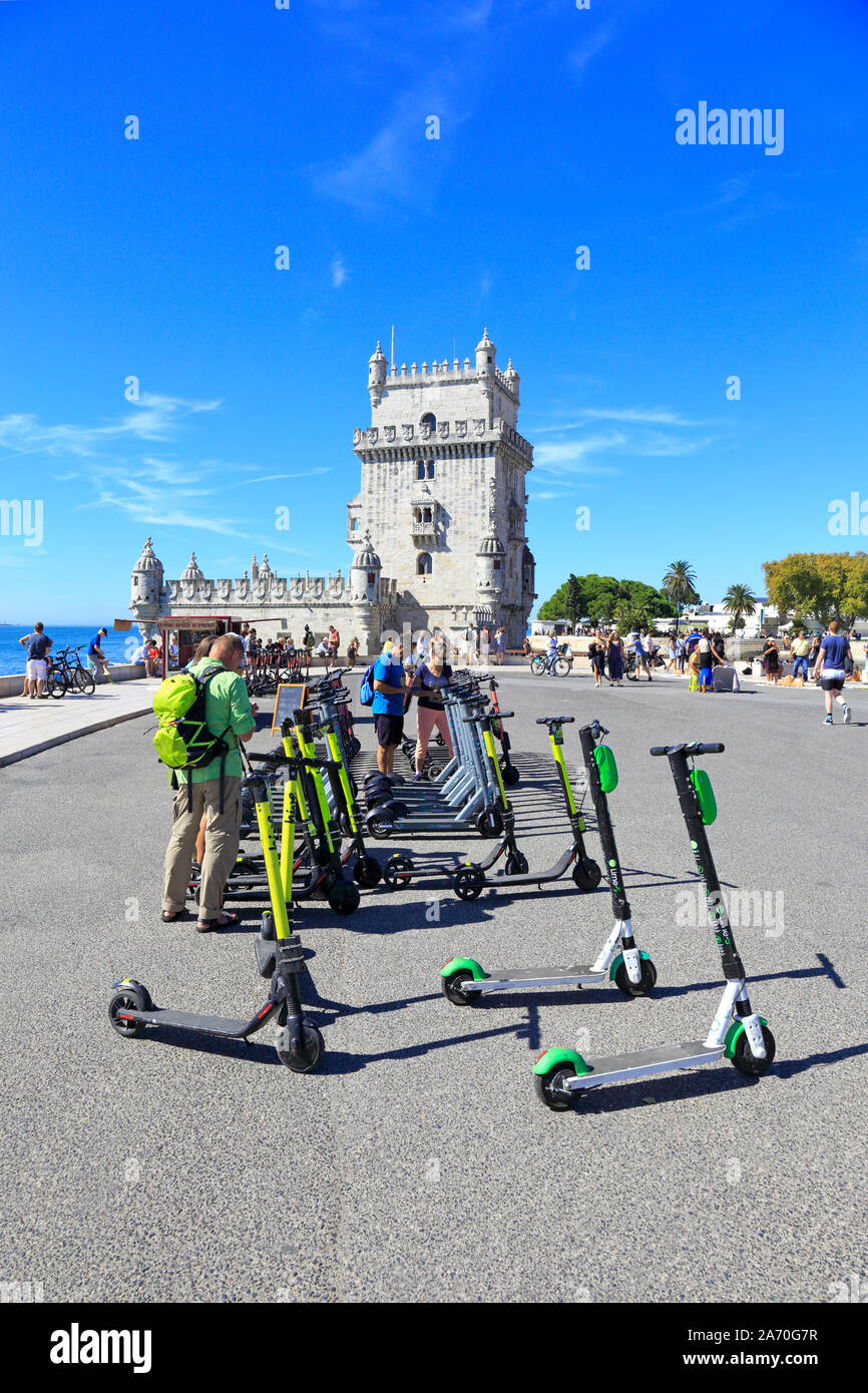I turisti noleggio di scooter elettrici da la Torre di Belem, ufficialmente la torre di Saint Vincent, un sito Patrimonio Mondiale dell'UNESCO, Lisbona, Portogallo. Foto Stock